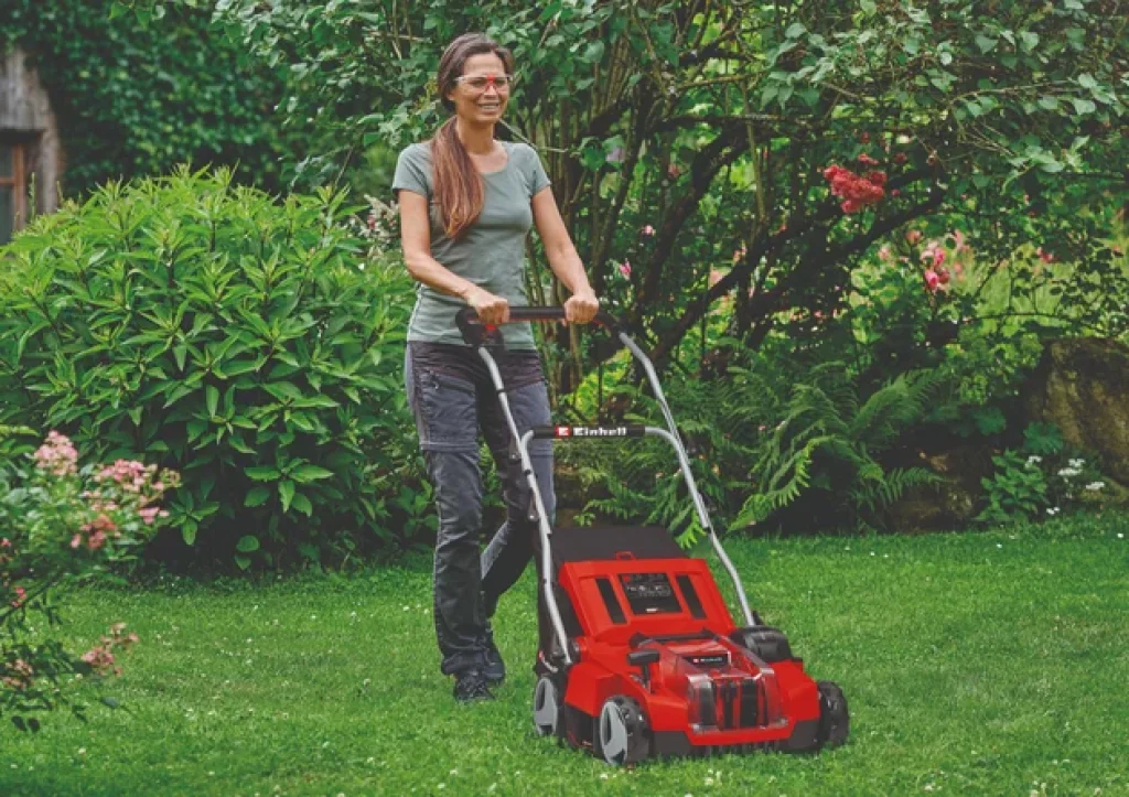 Une femme avec des lunettes de protection en train de passer le scarificateur Einhell GE-SA 36/35 Li-Solo.